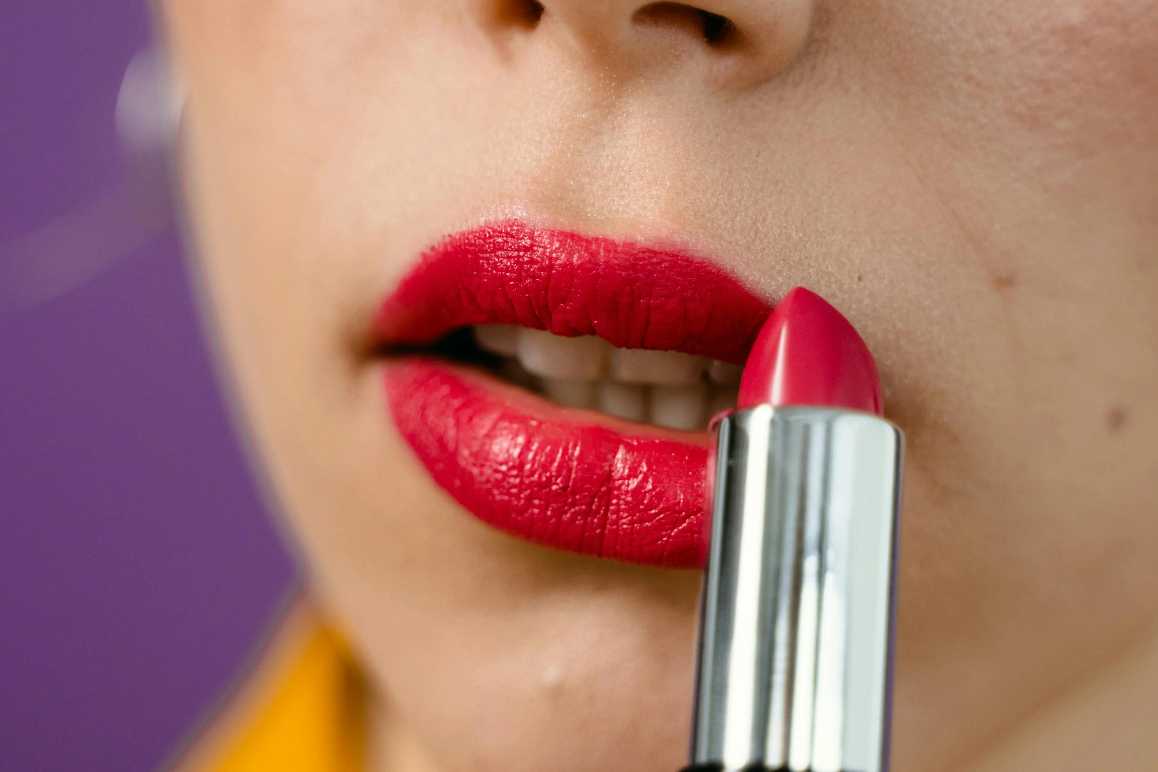 Ilustrasi menggunakan lipstik merah. (Foto: Pexels/MART PRODUCTION)