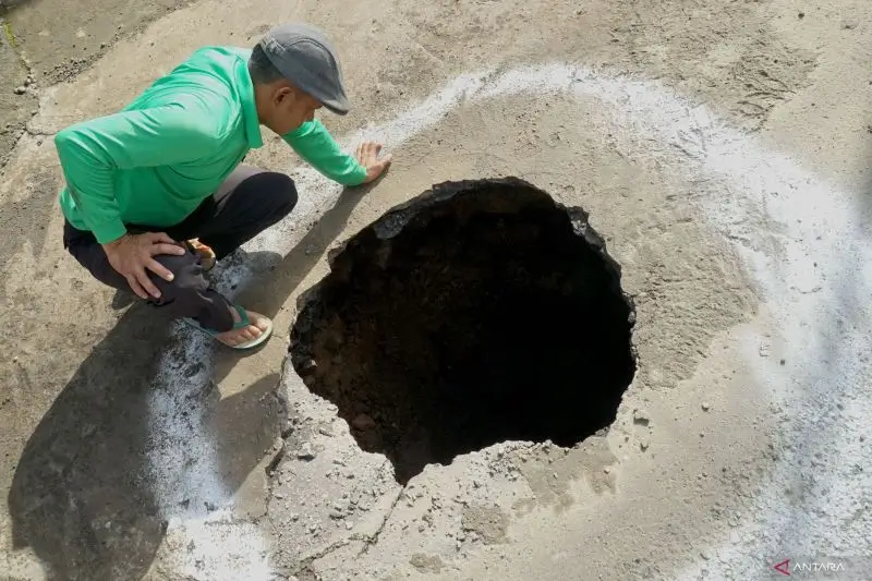 Fenomena sinkhole yang terjadi di tengah ruas jalan raya Jalan Selingkar Wilis, Tulungagung, Jawa Timur, Kamis (27/2/2025). ANTARA FOTO/Destyan Sujarwoko