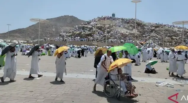 Menghindari cuaca panas di Padang Arafah, jamaah haji menggunakan payung untuk melindungi diri dari sengatan sinar matahari yang sangat ekstrim. (Foto: Antaranews.com)