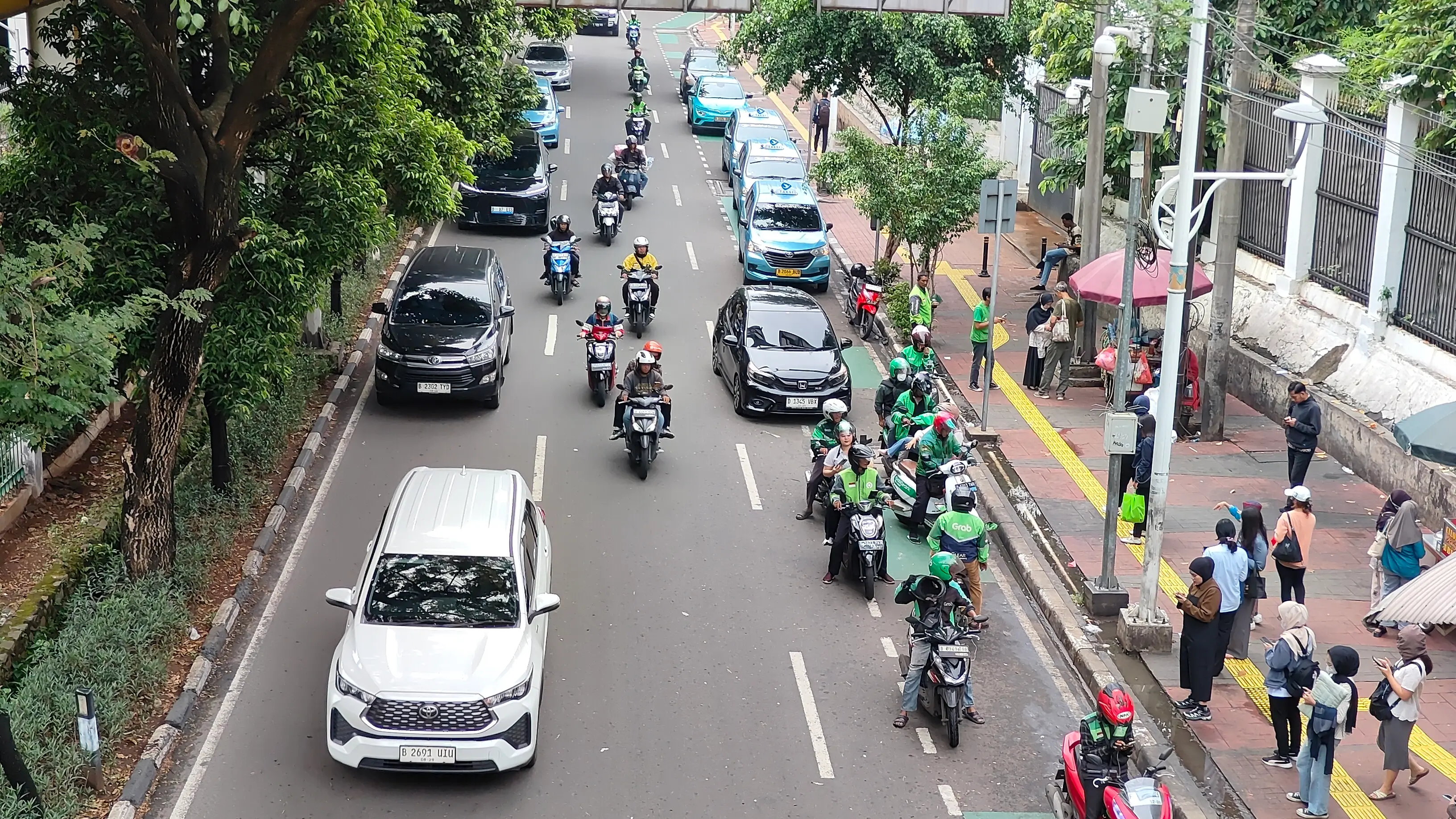 Ilustrasi: Pengendara roda dua dan roda empat di jalan raya. (Foto: Dok. ThePhrase.id/Rangga Bijak)