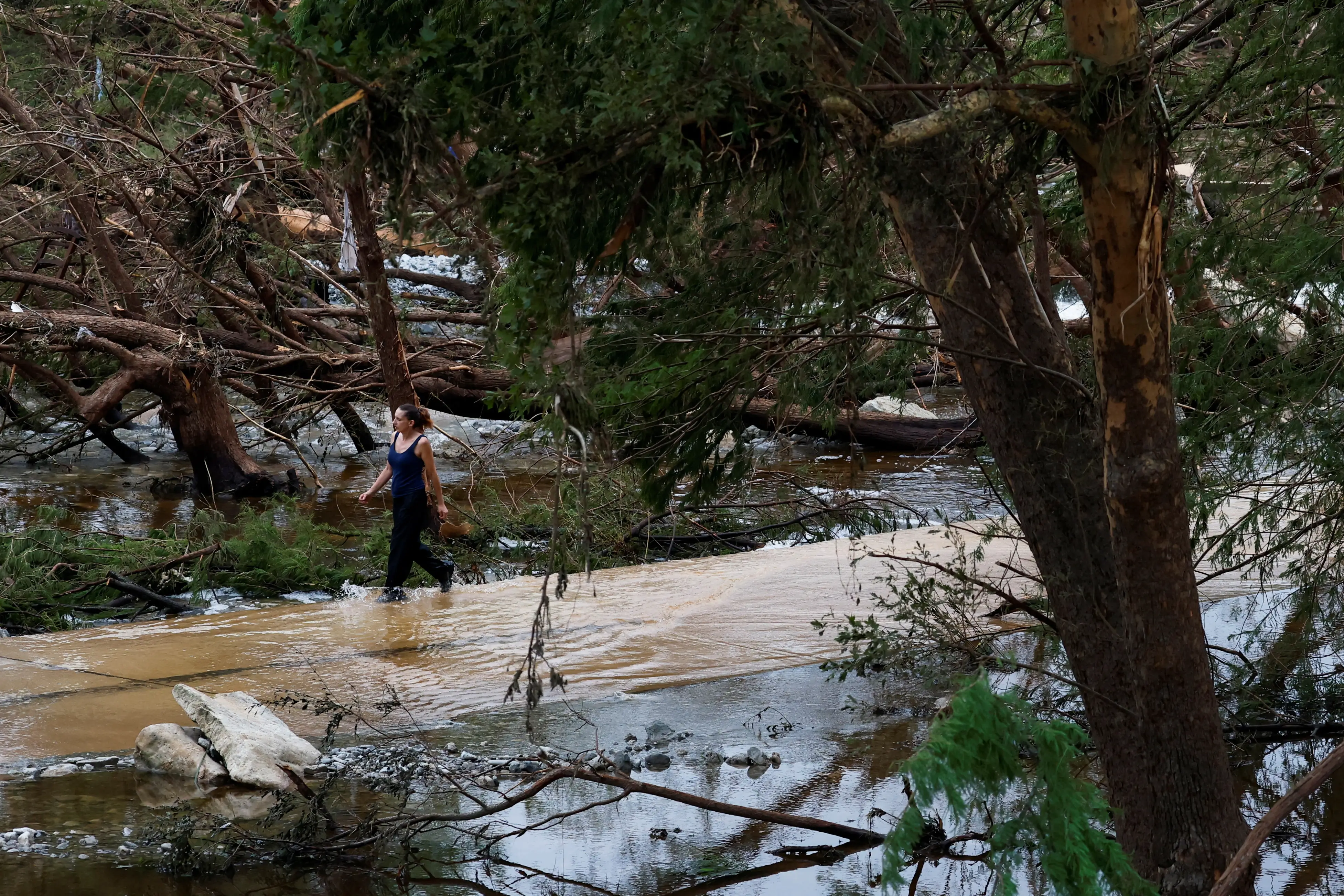 Seorang wanita berjalan di jalanan setelah banjir bandang di Hunt, Texas, AS, 6 Juli 2025. (Foto: REUTERS/Marco Bello)