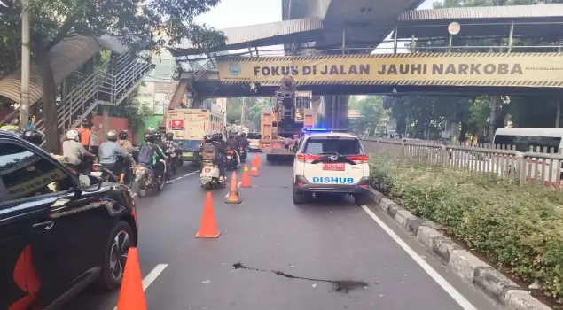 Petugas Dishub melakukan pengaturan lalu lintas di Jalan Kapten Tendean, Mampang Prapatan, Jakarta Selatan pada Selasa (14/07/26) pagi usai sebuah truk pengangkut crane menabrak JPO. (Foto: X/TMCPoldaMetro)