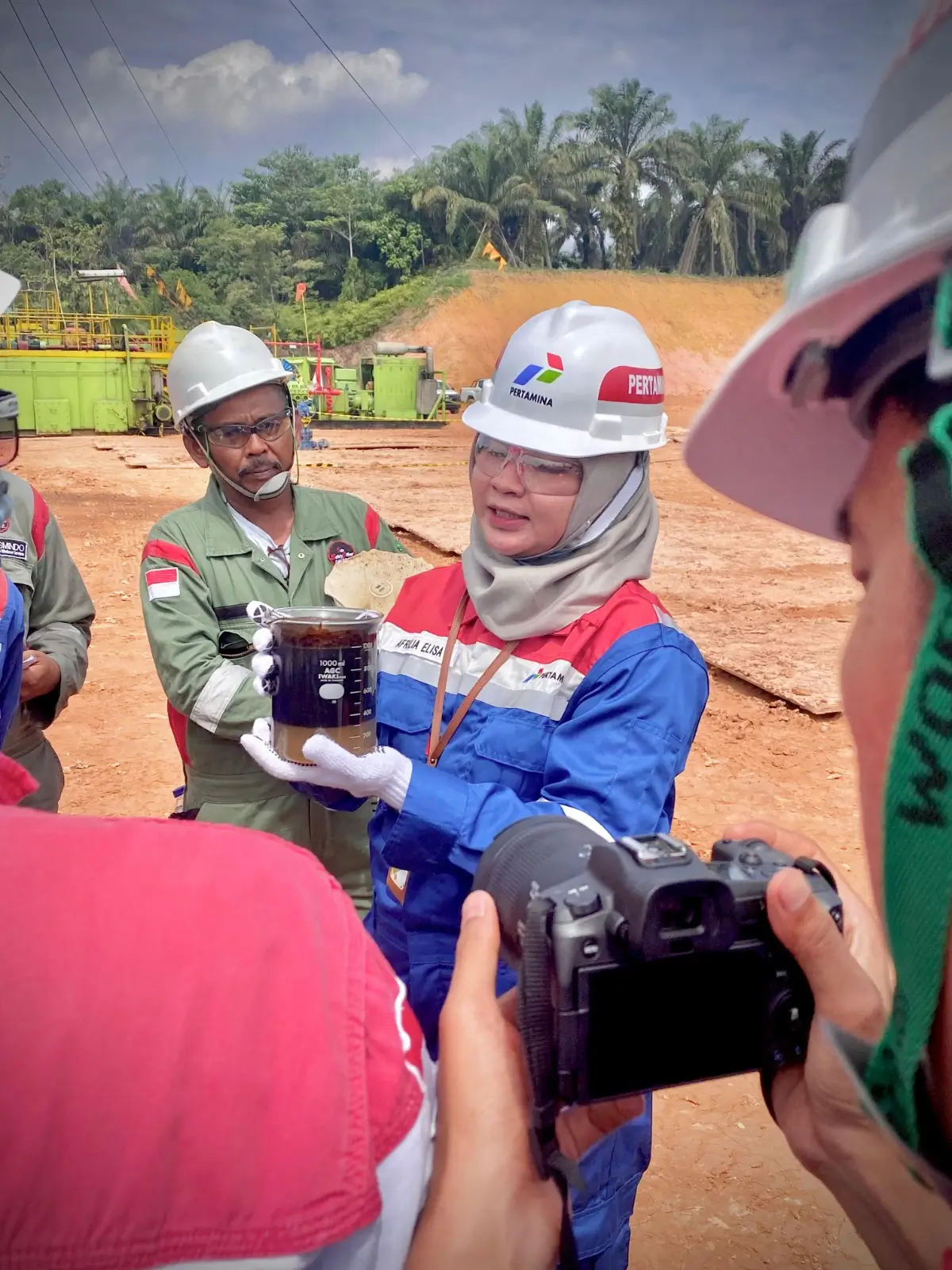 Afrilia Elisa, Sr Petroleum Engineer PHR, Kepala Proyek VENUS, tengah menunjukkan bejana berisi fluida lapisan minyak hasil dari sumur evaluasi menggunakan VENUS. (Foto: Dok. PHR)