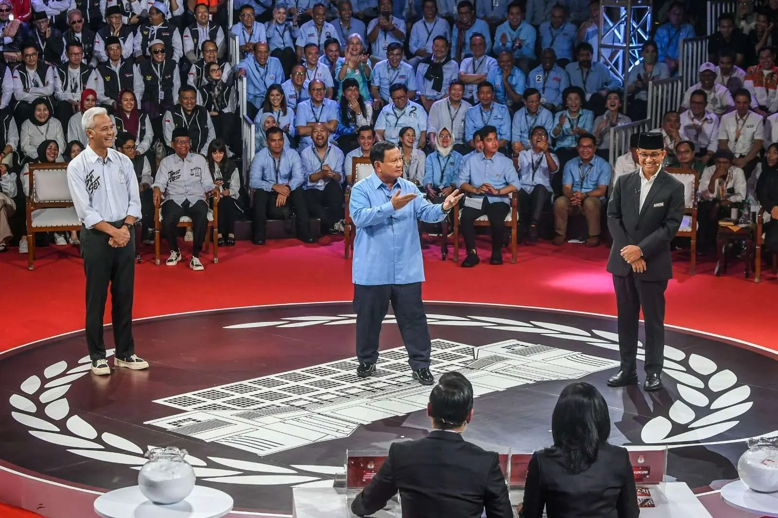 Capres nomor urut satu Anies Baswedan (kanan), Capres nomor urut dua Prabowo Subianto (tengah), Capres nomor urut tiga Ganjar Pranowo (kiri) beradu gagasan dalam debat perdana Capres dan Cawapres 2024 di Gedung KPU, Jakarta, Selasa (12/12). Foto: Antara/Galih Pradipta